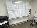 a whiteboard in the corner of a room with a whiteboard on the wall