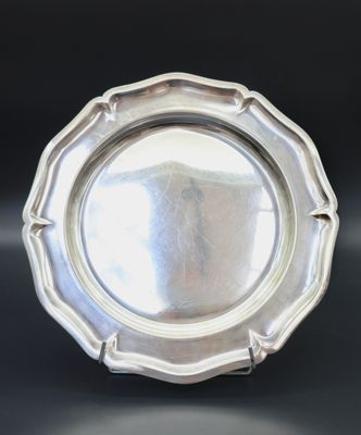 an antique silver plate on a black table with a black background