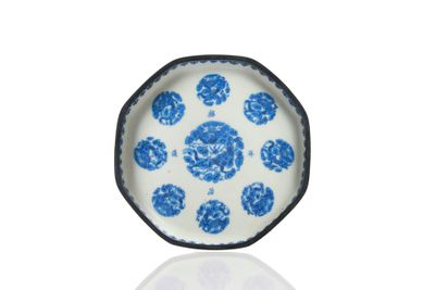 une image représentant une assiette bleue et blanche posée sur une surface blanche