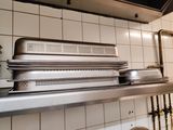 stainless steel counter top in a commercial kitchen with pots and pans on it