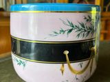 a pink bowl with a blue lid sitting on a table