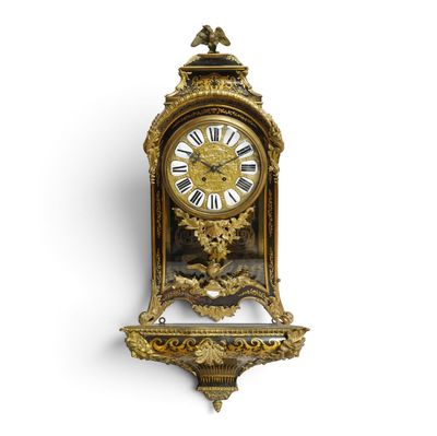 une horloge dorée sur un mur blanc, avec un fond blanc