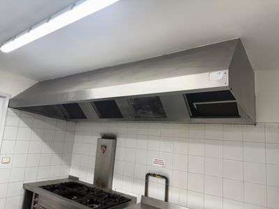 une image d'une cuisine avec une cuisinière et une hotte aspirante