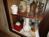 a shelf with a lot of vases and cups on it