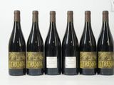 six bouteilles de vin sont alignées sur une surface blanche