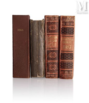 trois vieux livres posés l'un sur l'autre sur une surface blanche