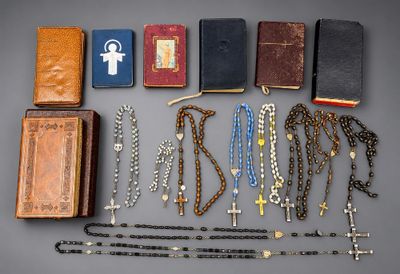 beaucoup de chapelets et d'autres objets religieux sur la table