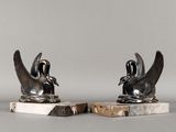 une paire de sculptures d'oiseaux en noir et blanc sur des socles en marbre