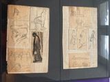 two pages of drawings on display in a glass case