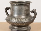 a silver vase that is sitting on a table