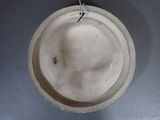 a white hat hanging from a hook on the wall