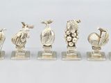 un ensemble de figurines en argent représentant des oiseaux et des fleurs, posées sur des socles