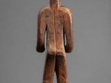 an image of a wooden statue of a man with a hat on his head