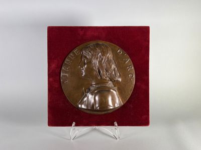un gros plan d'une médaille posée sur un socle, sur fond blanc
