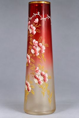 un vase rouge orné de fleurs, posé sur une table