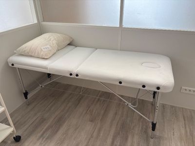 a white table with a pillow on it in the corner of a room