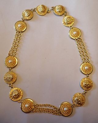 gros plan d'un collier en or sur une surface blanche