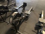 a row of rowing machines in a gym room