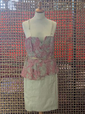 a dress on a mannequin stand in front of a screen