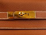 a brown hermes bag with gold hardware