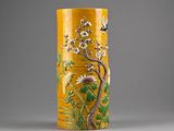 un vase jaune sur lequel sont peints des fleurs et des oiseaux