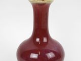 a red vase with a gold rim on a white background