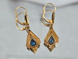 pair of gold and blue stone earrings on a white surface