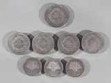 six pièces de monnaie britanniques différentes disposées en pyramide sur une surface blanche