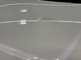 a close up of a white car with a sticker on it ' s hood
