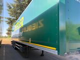 un gros camion vert garé sur le bord de la route