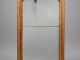un grand miroir à cadre doré orné d'un motif décoratif