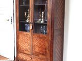 un meuble en bois avec des portes en verre dans le coin d'une pièce
