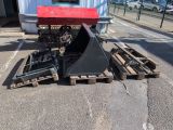 a picture of a fork attachment sitting on pallets in a parking lot