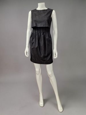 un mannequin vêtu d'une robe noire et de chaussures blanches