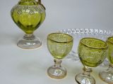four green glass goblets sitting on a white table
