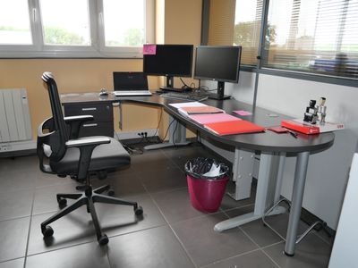 a desk with a chair and a computer on it