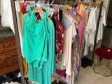 a lot of clothes hanging on a rack in a room