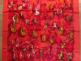 une image représentant une écharpe rouge ornée d'instruments de musique