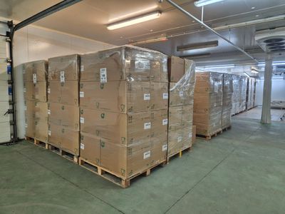 une grande quantité de cartons empilés sur des palettes dans un entrepôt