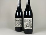 two bottles of wine sitting next to each other on a table