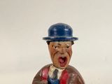 a figurine of a man with a hat and a cane