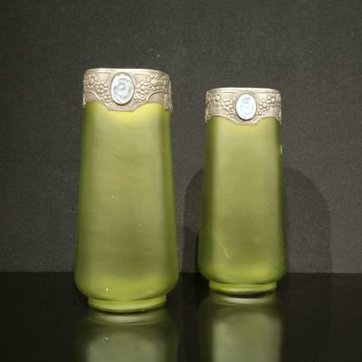 deux vases verts posés sur une table, sur fond noir