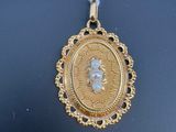 une photo d'un collier en or sur lequel figure le portrait d'une femme