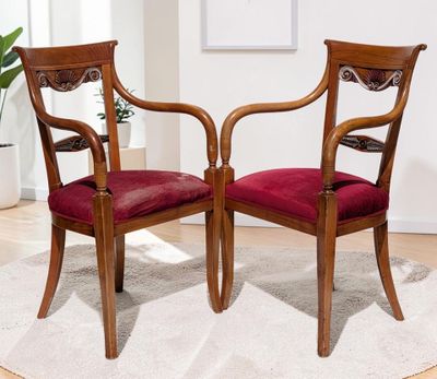 deux chaises en bois posées sur un tapis blanc dans un salon