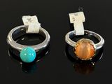pair of rings with stones on black surface with price tag