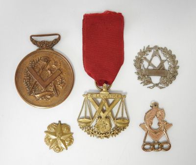 trois médailles et une médaille sont posées sur une surface blanche