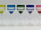 several different colored wine glasses are lined up in a row
