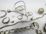 a lot of silver jewelry on a white table
