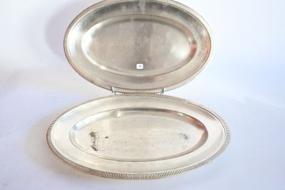 un plat en argent muni d'un couvercle en argent, posé sur une table blanche