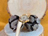 a watch that is sitting on top of a piece of wood